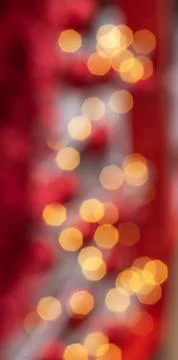 Soft warm bokeh lights create a festive holiday mood with red backdrop Stock Photos