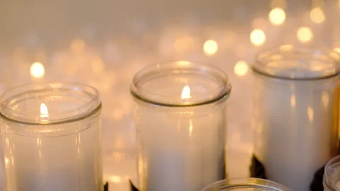 Soft, warm shot of many memorial candles closely arranged and glowing. The Stock Footage 320579092
