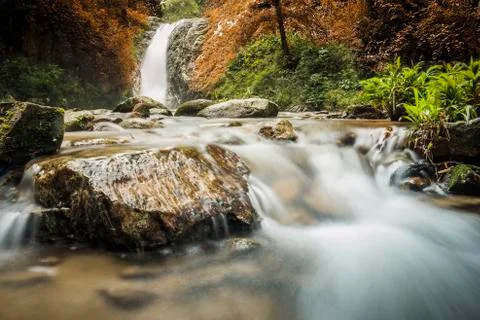 Soft water of the stream in the natural park, Beautiful waterfall in rain for Фото