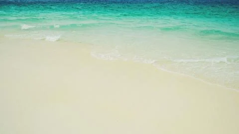 Soft wave of blue ocean on sandy beach Stock Photos