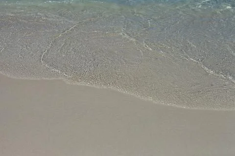 Soft Wave Of Blue Ocean On Sandy Beach. Background. Selective focus. Stock Photos