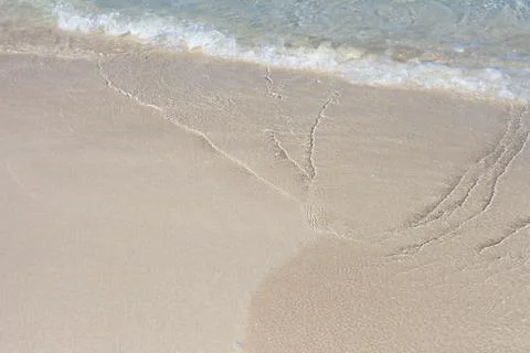 Soft Wave Of Blue Ocean On Sandy Beach. Background. Selective focus. Stock Photos
