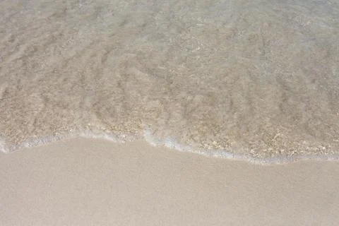 Soft Wave Of Blue Ocean On Sandy Beach. Background. Selective focus. Stock Photos