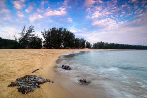 Soft wave of blue ocean on sandy beach during sunrise . Soft wave on sand bea Stock Photos