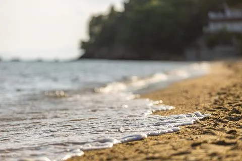 Soft Wave Of Blue Ocean On Sandy Beach at Sunset. Background. Selective focus. 스톡 사진