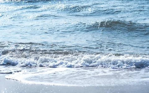 Soft wave of blue ocean on sandy beach. Copy space for text. Stock Photos
