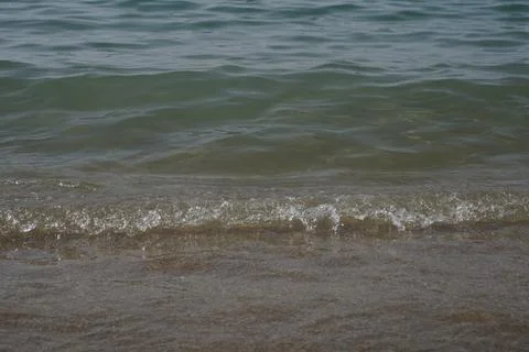 Soft wave of blue ocean on sandy beach. Background. Selective focus Stock Photos