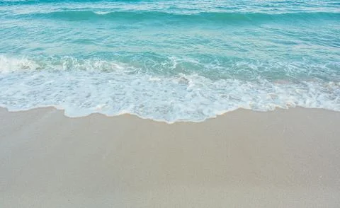 Soft wave of blue ocean on sandy beach. Summer vacation in island. clear az.. Stock Photos