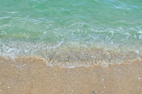 Soft wave of emerald ocean on sandy beach for background. 스톡 사진