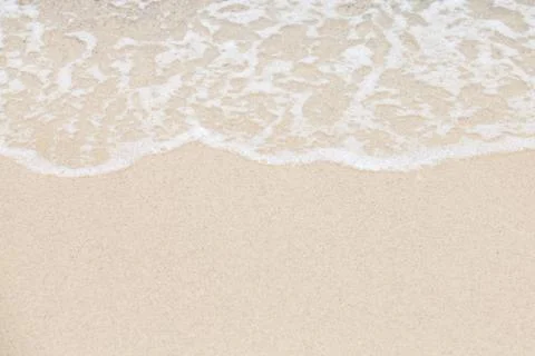 Soft wave of ocean on sandy beach. Background. Stock Photos