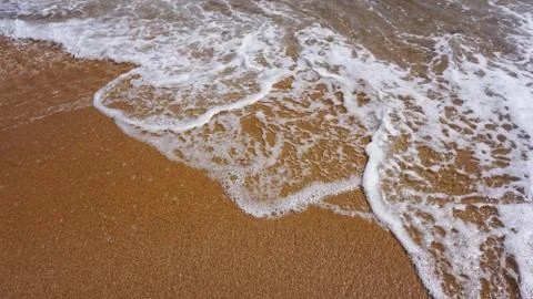 Soft wave of ocean on sandy beach, copy space, background. Stock Photos
