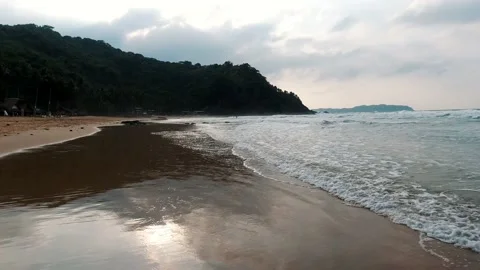 Soft wave wash over a topical sea beach at sunset. Close-up calm waves of the Stock Footage 135403813