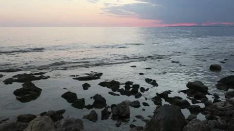 Soft waves during sunset on a rocky beach near the port in Ayia Napa, Cyprus Stock Footage 164291694
