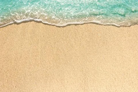 Soft waves with foam of blue ocean on the sandy beach Stock Photos