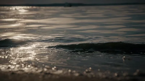 Soft waves gently lapping on a sandy beach at sunset. Slow motion video Stock Footage 286121811
