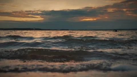 Soft waves gently lapping on a sandy beach at sunset. Slow motion video Video stock 286121994