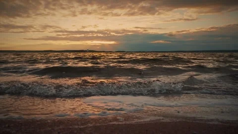 Soft waves gently lapping on a sandy beach at sunset. Slow motion video Video stock 286122017