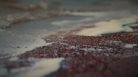 Soft waves gently lapping on a sandy beach at sunset. Slow motion video Video stock 286122113