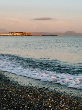 Soft waves gently washing pebble beach at sunset, creating serene and peaceful Foto stock