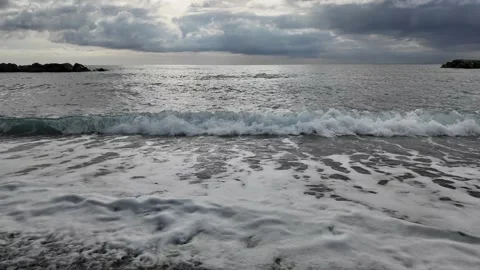 Soft waves roll onto sandy beach cloudy winter day Bogliasco village. Stock Footage 327072101