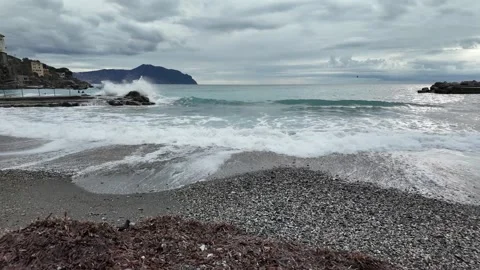 Soft waves roll onto sandy beach in winter coastal village Bogliasco Stock Footage 327288689