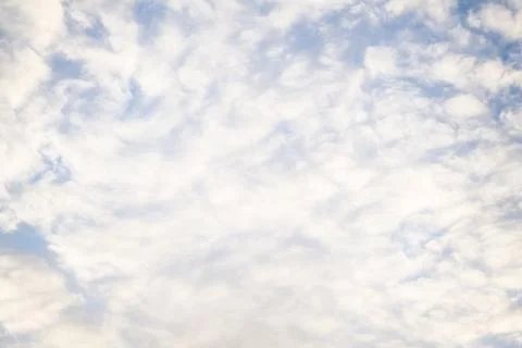 Soft white altocumulus clouds over a pale blue sky, full frame texture Stock Photos