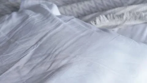 Soft white bedding with textured blanket on a cozy bed setting Foto stock