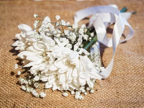 Soft white blooms rest on burlap Stock Photos