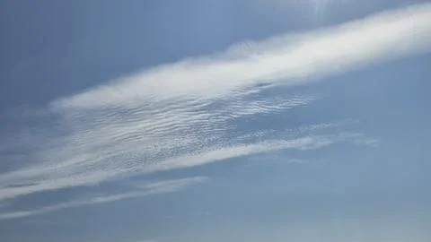 Soft white cloud streaks in blue sky Stock Photos