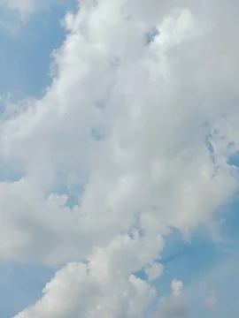 Soft white clouds against a clear blue sky Stock Photos