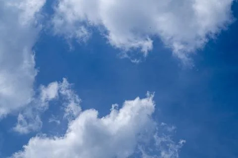 Soft white clouds in a bright blue spring sky. 写真素材