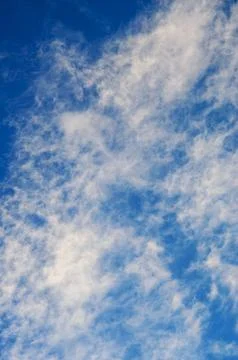 The soft white clouds create a stunning contrast against the vibrant blue s.. Stock Photos