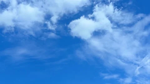 Soft white clouds drifting across clear blue sky time lapse Stock Footage 313671980