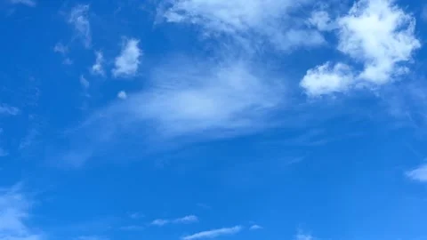 Soft white clouds drifting across clear blue sky time lapse Stock Footage 313672122