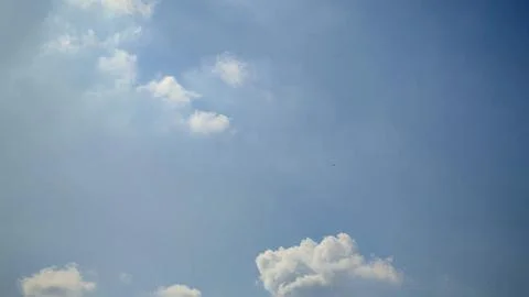 Soft white clouds drifting slowly across vast clear blue sky provides seren.. Stock Photos