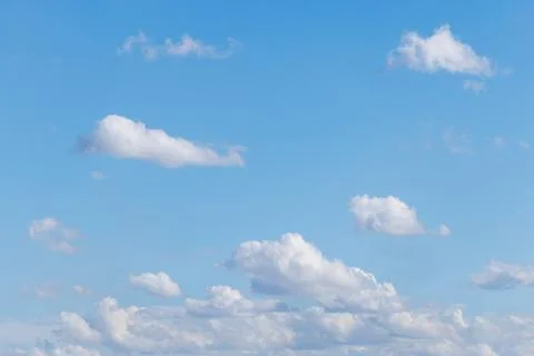 Soft white clouds float gently in clear blue sky Stock Photos