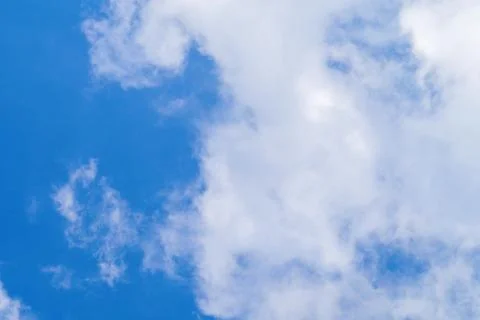 Soft white clouds floating across vibrant blue sky on bright day. Beautiful d Stock Photos