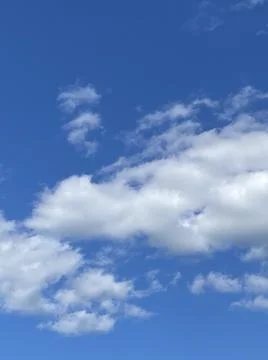 Soft white clouds floating on a bright blue summer sky Foto stock