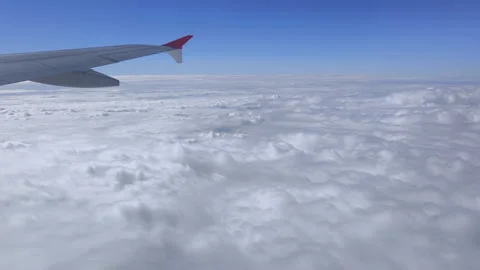 Soft white clouds move quickly below the wing as the plane glides forward Stock Footage 323202585