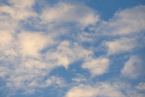 Soft white clouds scattered across clear blue sky in bright daylight background Stock-Fotos