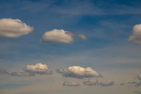 Soft white cumulus clouds drifting across calm blue evening sky with peacef.. Stock Photos