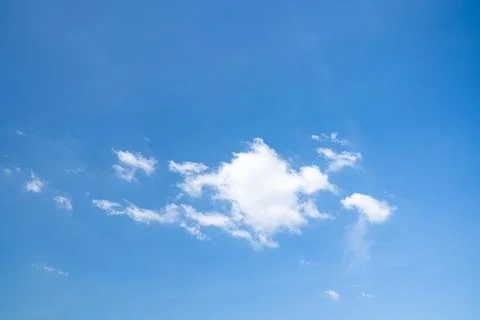 Soft white cumulus clouds spread through a bright blue sky, giving a beauti.. Foto stock