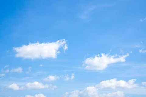 Soft white cumulus clouds spread through a bright blue sky, giving a beauti.. Stock Photos