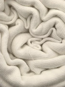 Soft white fabric forms a delicate spiral pattern creating a cozy effect 写真素材