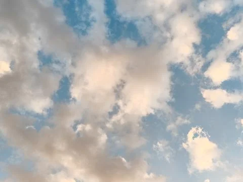 Soft white fluffy clouds in a pastel blue sky background Stock Photos