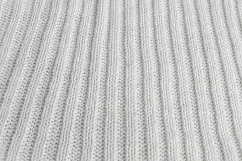Soft white knitted fabric showcasing intricate ribbing patterns for cozy Stock Photos
