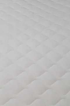 Soft white mattress close-up background with selective focus. 库存照片
