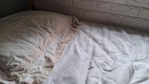 Soft white quilted bed sheets resting on a comfortable mattress Stock Photos