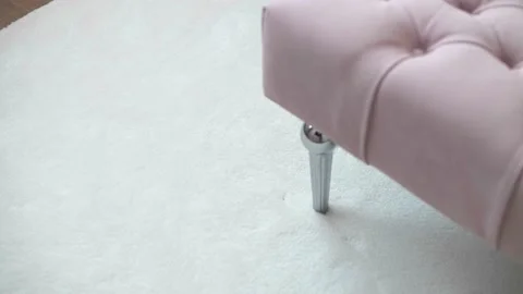 Soft white rug and a soft pink bedside pouf in a modern room Stock Footage 159806929
