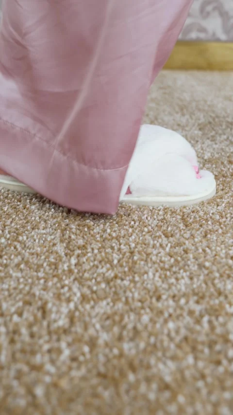 Soft white slippers on the beige Interior pile carpet. vertical video Video stock 307497697